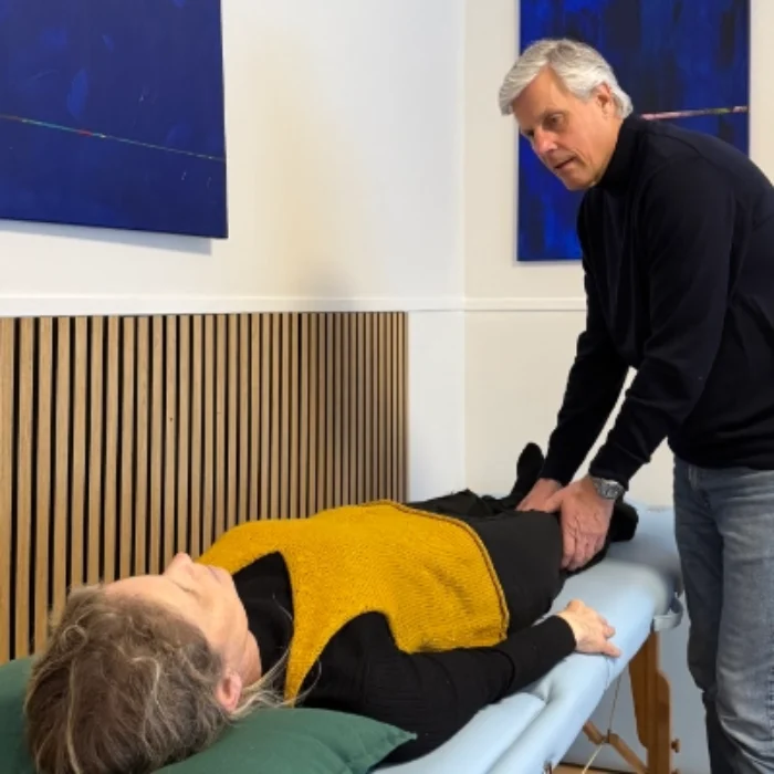 Amund Norman Otte behandler en klient på briksen i klinikken